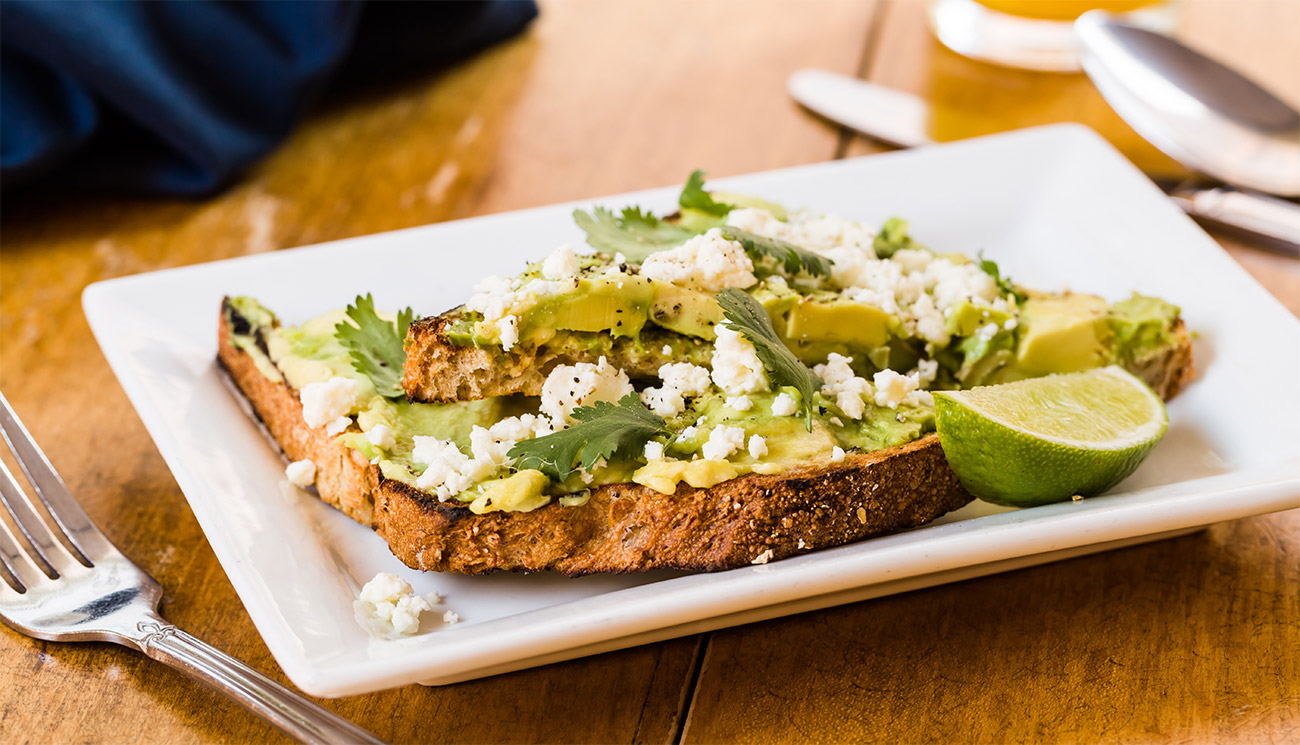 Avocado toast - wheat, feta, cilantro, lime, cracked pepper.