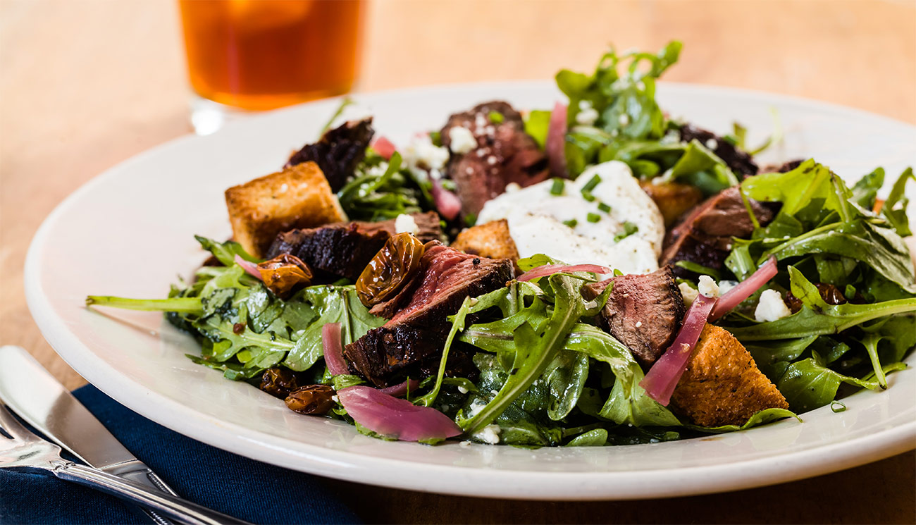 Steak salad - arugula, hanger, poached egg, pickled red onion, cherry tomato, bleu cheese, brioche, red wine vinaigrette.